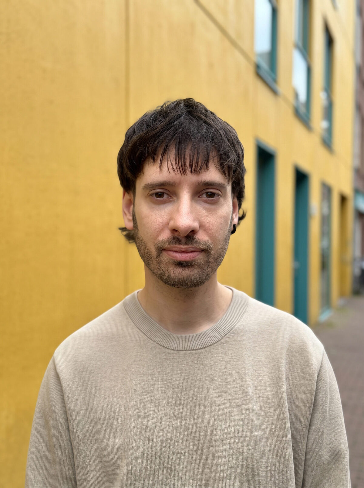 Portrait of Julen De La Serna in front of a yellow wall